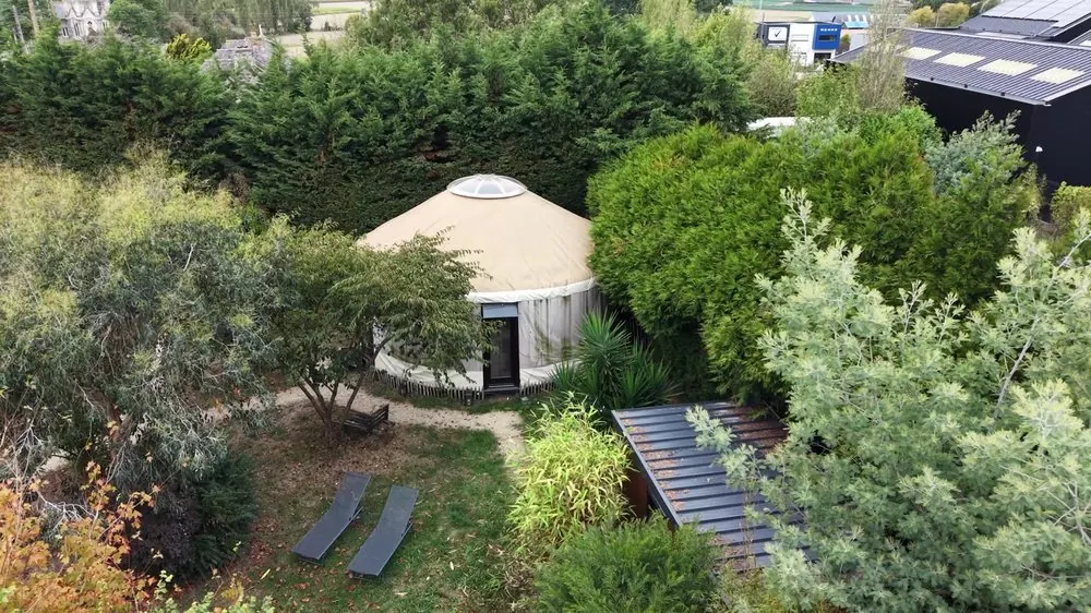 Vue aérienne d'une yourte entourée de végétation dans un jardin